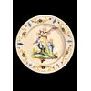Piatto in maiolica con tesa decorata a festoni e motivi floreali e scena nel cavetto con ‘arcangelo Raffaele e Tobiolo’.Pavia.
