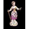 Sculturina in porcellana,figura di contadina con bastone e grappolo d’uva.Meissen.