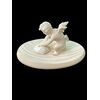 Piccola scultura in avorio raffigurante cupido che affila la freccia.