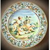 Majolica plate with Raphaelesque and grotesque decoration on the brim and three cherubs in the cavetto.Manifattura Molaroni.Pesaro     