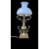 Lampada in ottone con corpo rastremato e bracci laterali rocaille.Cappello in vetro lattimo.