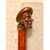 Bastone con pomolo in legno raffigurante figura maschile con basette e cappello.