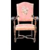 Poltrona in noce con braccioli a volute e gambe tornite.