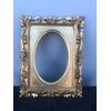 Carved and gilded wooden frame with applied oval interior.     