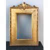 Frame in carved wood and gold leaf with plant and geometric motifs engravings and upper rocaille shield.     