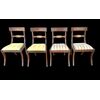Four walnut chairs with geometric pattern decoration.