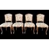 Four walnut chairs with floral pattern carvings.