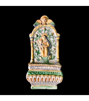 Acquasantiera in maiolica con motivi vegetali e geometrici in rilievo e figura di Madonna con Bambino al centro.Manifattura di Deruta.