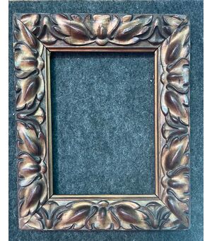 Carved and gilded wooden frame with stylized leaves motif.     