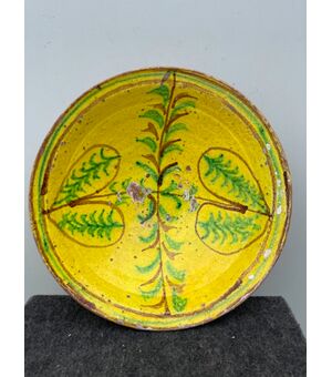 Piatto in ceramica ingobbiato a decoro ‘popolaresco’ con elementi geometrici stilizzati.'Verso' parzialmente invetriato.Calabria.