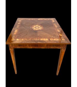 Tavolino a 4  gambe in noce con lastronatura a fiamma e intarsi con motivi geometrici e floreale.Piano sdoppiabile e  chiudibile  a libro