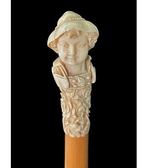 Bastone con pomolo in avorio raffigurante un busto di giovane con cappello.