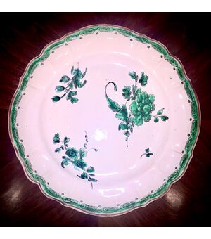 Majolica plate in green monochrome on third fire with floral and geometric decoration.Ferretti manufacture, Lodi. 24 cm.     