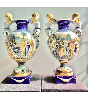 Coppia di vasi in maiolica con prese laterali a forma di arpia e decoro istoriato.Autore:Tito Magrini.Pesaro.