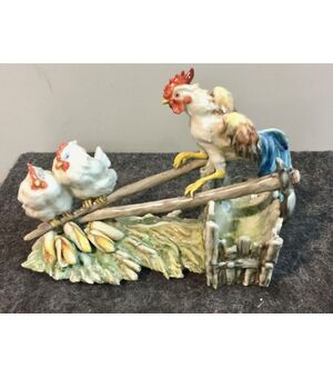 Gruppo in ceramica policroma raffigurante Gallo e due galline nel pollaio.Manifattura di Guido Cacciapuoti.Milano