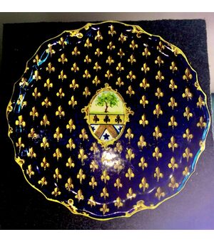 Piatto alzata in maiolica decorato con motivo a giglio mediceo e stemma nobiliare al centro.Manifattura di Angelo Minghetti,Bologna.