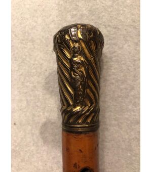 Stick with golden metal knob with neoclassical scenes.     