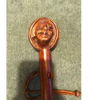 Stick with wooden knob depicting the head of a female figure.     