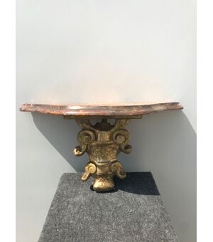 Carved and gilded wooden shelf with marbled lacquered top.     