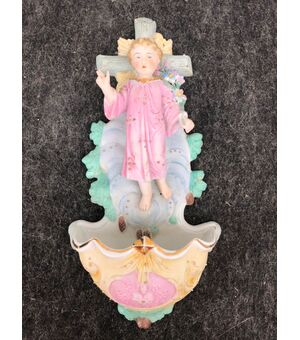 Acquasantiera in porcellana bisquit con figura di Gesù Bambino benedicente con mazzo di fiori.Germania.