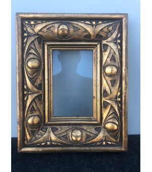 Carved and gilded wooden frame with art deco decorations.     