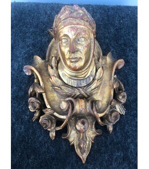 Fregio in legno intagliato e dorato con motivi vegetali stilizzati e figura centrale di Dante.