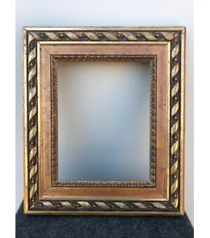 Carved and gilded wooden frame with tourchon motif.     