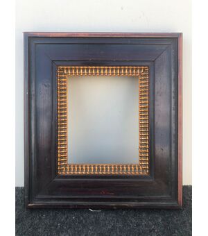 Carved frame in mahogany wood with gilded part.     