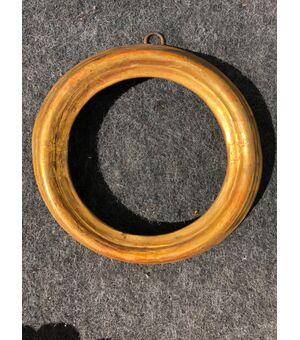 Round frame in carved and gilded wood.     
