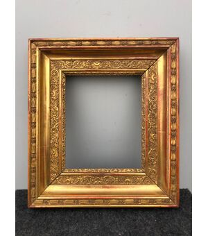 Frame in carved wood and gold leaf with plant and rocaille motifs.     
