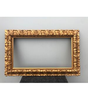Carved and gilded wooden frame with leaf motif.     