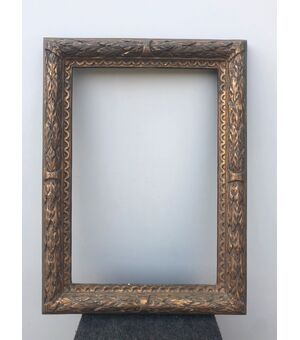 Carved and gilded wooden frame with plant motifs in relief.     