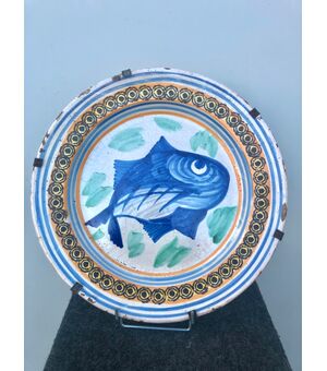 Majolica plate decorated with a fish in the cable and geometric motifs on the brim. Vietri manufacture     