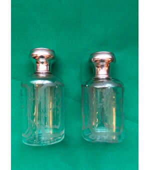 Pair of crystal perfume bottles engraved with floral motifs and silver caps.France.     