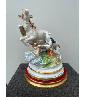 Polychrome porcelain group depicting a hunting scene with a dog attacking a deer.     