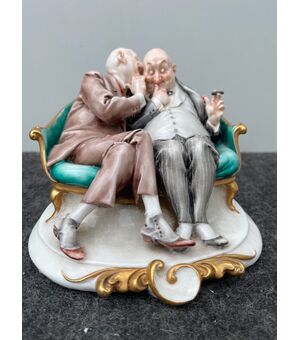 Scultura in porcellana caricaturale raffigurante coppia di amici che si parlano nell’orecchio.Giuseppe Cappe’.