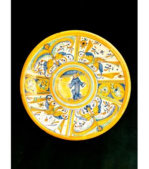 Majolica cutting board with Raphaelesque neighborhood decoration and rocaille plant motifs. Central round with figure of Saint. Manufacture of Deruta.     