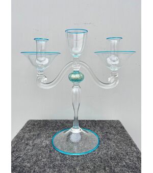 Candeliere in vetro trasparente leggermente iridato con dettagli azzurri.Presenta  forma umana stilizzata a due bracci.Manifattura Seguso.Murano.