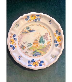Majolica plate decorated with floral motifs and architectures, called al &#39;casotto&#39;. Ferniani manufacture, Faenza.     