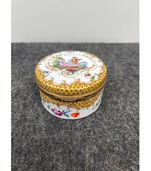 Porcelain box decorated with a gallant scene and floral and geometric motifs.Volute rocaille in relief.Signed by Edme&#39;Samson.France.     