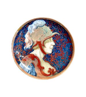 Majolica plate with metallic luster depicting the profile of a soldier with helmet and stylized vegetable decorations.Ginori manufacture.     