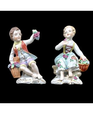 Coppia di figurine in porcellana raffiguranti personaggio femminile e maschile con cesto di frutta e fiori.Manifattura Ginori.