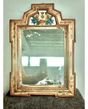 Specchiera in legno laccato con dipinto su vetro a soggetto floreale.Italia settentrionale.