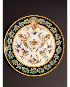 Coppia di piatti in maiolica decorati a raffaellesche nell’umbone e motivi a tralci di vite sulla tesa.Manifattura Ginori.