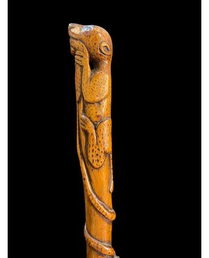 Bastone popolare in pezzo unico di legno inciso con figura di giaguaro che attacca un serpente.