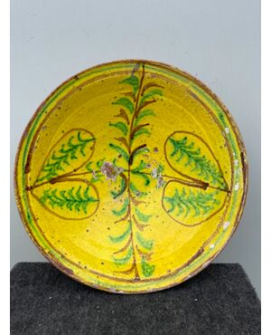 Piatto in ceramica ingobbiato a decoro ‘popolaresco’ con elementi geometrici stilizzati.'Verso' parzialmente invetriato.Calabria.