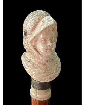 Bastone con pomolo in avorio raffigurante busto di bimbo mascherato da uccello.