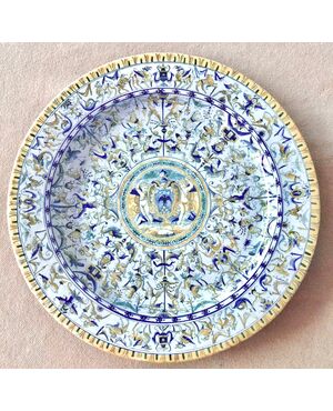 Large majolica plate with grotesque and Raphaelesque decoration with noble coat of arms in the center. Manufacture by Tito Magrini, Pesaro.     