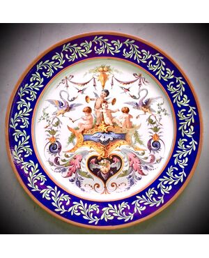 Grande piatto in maiolica decorato con putti,grottesche e motivi vegetali.Manifattura Ginori.