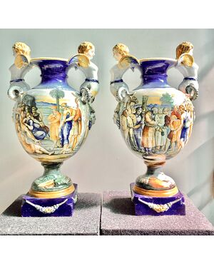 Pair of majolica vases with side sockets in the shape of a harpy and historiated decoration.Author: Tito Magrini.Pesaro.     